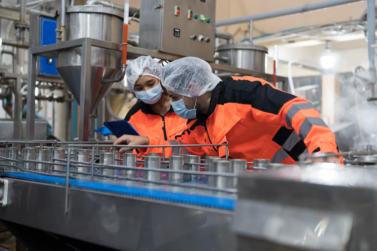 Factory workers collaborating in manufacturing environment
